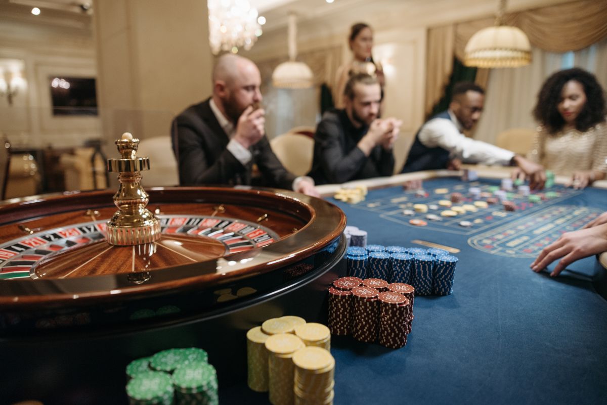 Meja roulette dengan dealer dan pemain