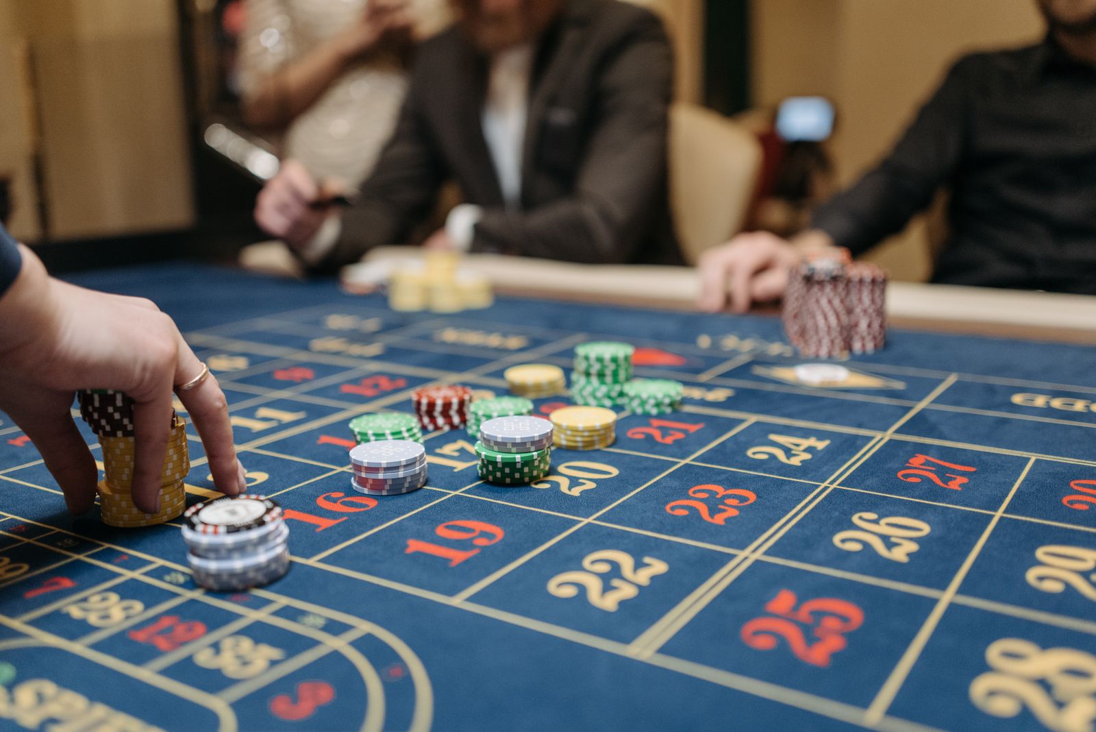 Tangan pemain menempatkan chip di meja roulette